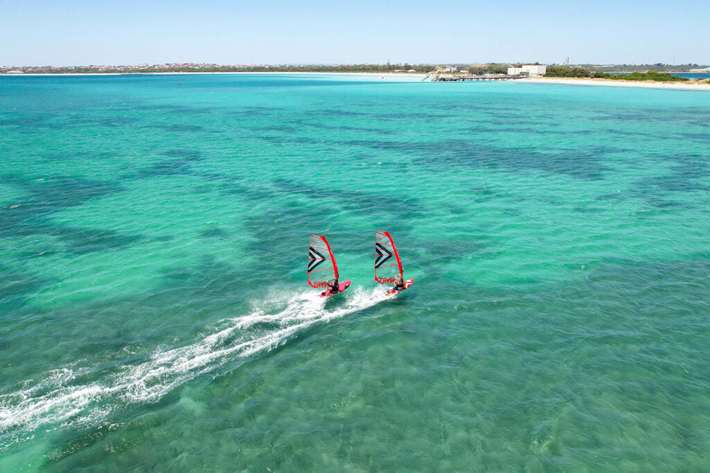 zwei Windsurfer auf karibischen Wasserfarben